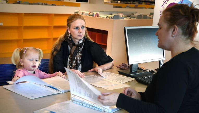 Corine van den Hurk, moeder van een dochtertje van 2, zoekt in de bibliotheek van Wageningen naar een baan in de ouderenzorg. Beeld Marcel van den Bergh / de Volkskrant