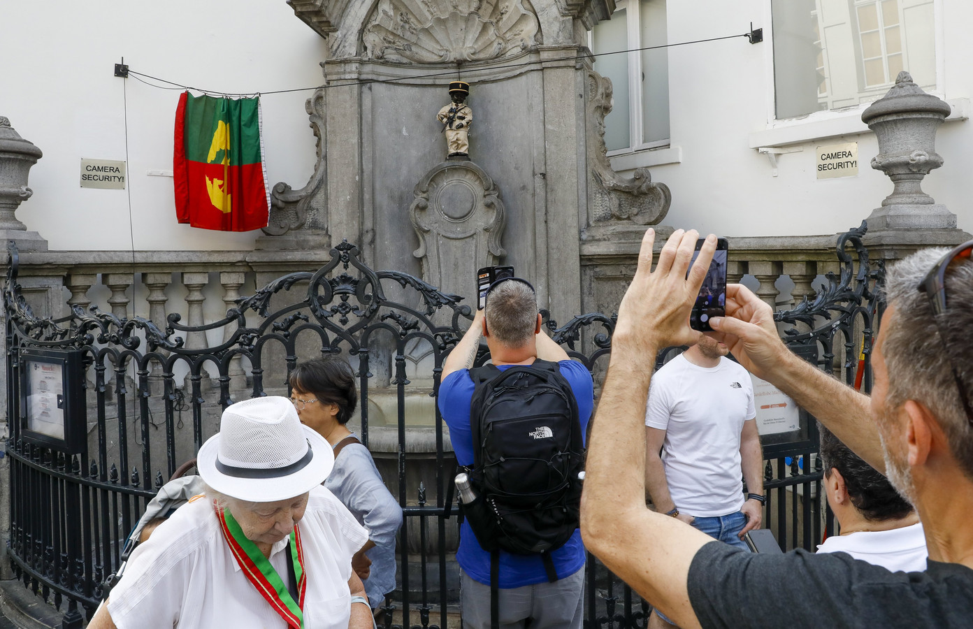 Toeristen nemen foto's van Manneken Pis verkleed als een Saint-Tropez-politieagent uit  ‘Le Gendarme et les Gendarmettes' in Brussel.