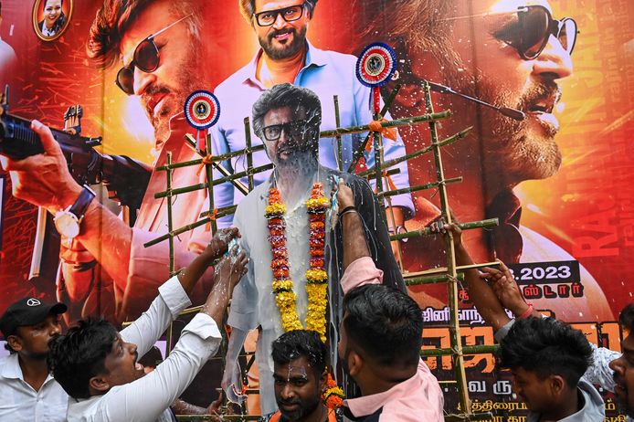 Fans splash milk on a banner with Rajinikanth's image on the first day of its release.