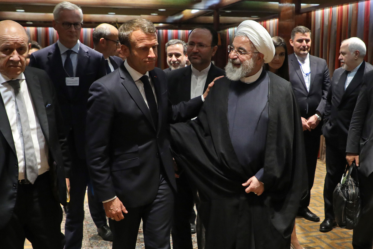 De Franse president Emmanuel Macron en de Iraanse president Hassan Rohani begroeten elkaar bij de VN-vergadering in New York.  Beeld AFP