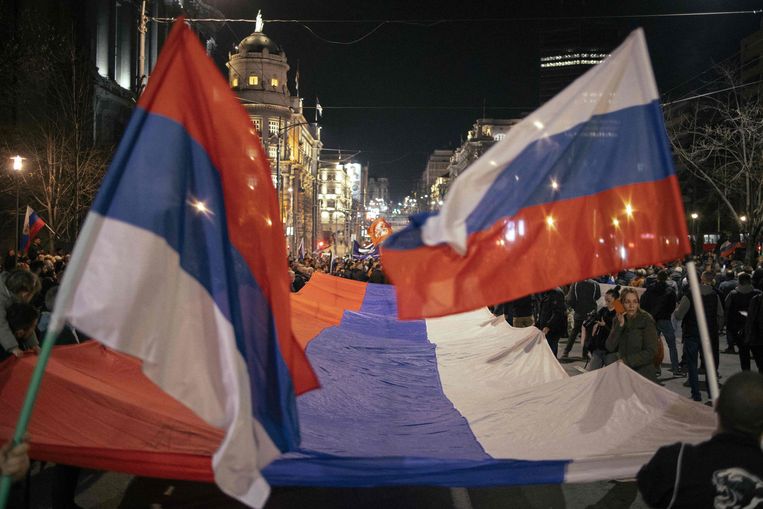 Russische en Servische vlaggen tijdens een pro-Rusland-betoging in Belgrado. Beeld AFP