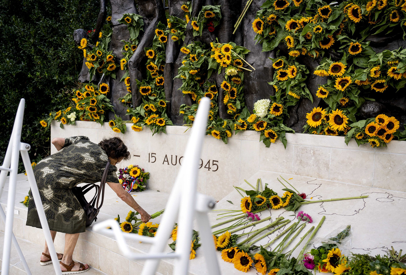 Een belangstellende legt bloemen neer bij het Indisch Monument tijdens de Nationale Herdenking van de capitulatie van Japan op 15 augustus 1945.