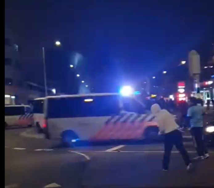 Oproerkraaiers gooien stenen naar de politie in Den Haag.