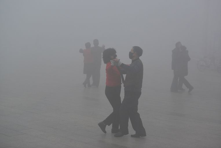 Paartjes dansen in de smog op een hevig vervuilde dag in Fuyang, China.  Beeld REUTERS