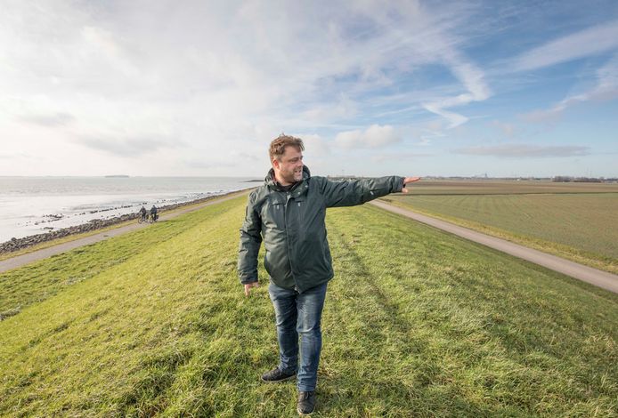 NIOZ-onderzoeker Jim van Belzen op de dijk bij Coudorpe. De Borsselepolder rechts ligt door bodemdaling lager dan de Westerschelde.
