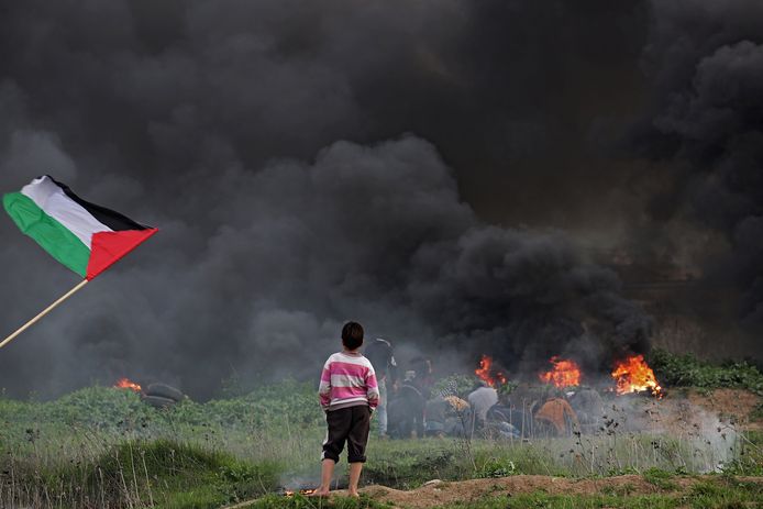 Een jongen kijkt toe hoe het Israëlisch leger en Palestijnse rebellen elkaar te lijf gaan aan de grens tussen Israël en de Gazastrook.