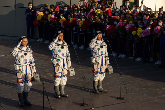 De Chinese astronauten Tang Hongbo, Nie Haisheng en Liu Boming  salueren voor vertrek.