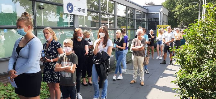 Een lange rij bij sporthal ‚t Timpke in Borculo. Het prikken zonder afspraak is zo populair dat het na een uur al wordt stopgezet.