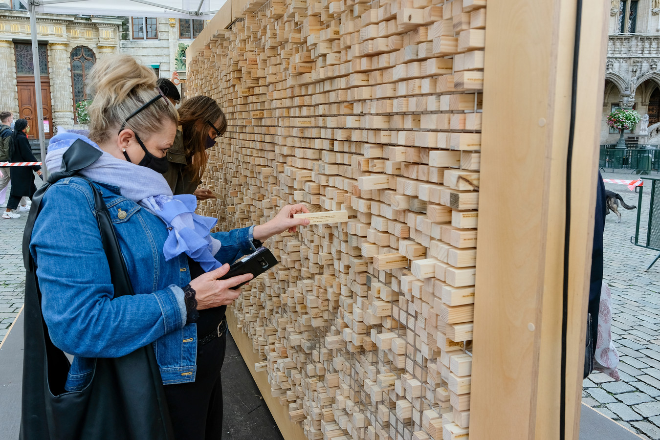 De interactieve kunstinstallatie bestaat uit een muur van honderden houten blokjes.