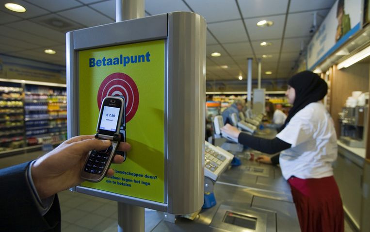 Afrekenen bij de AH to Go op het Amstelstation met een betaalmobieltje. Na het afmelden staat de kassabon in de telefoon. Foto ANP/Nils van Houts Beeld 