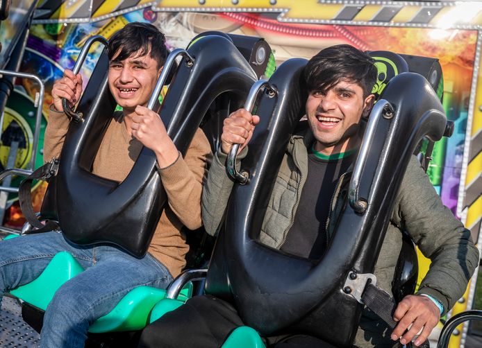 De broers Shahramd in een kermisattractie. Een groep vluchtelingen uit Syrië en Eritrea die een half jaar in Helmond verblijven, mochten donderdag gratis gebruik maken van kermisattracties op de voorjaarskermis.