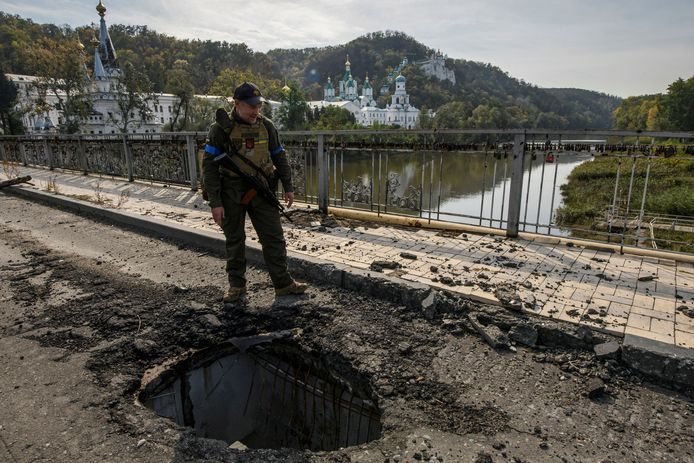 Een militair van de Oekraïense Nationale Garde staat bij een brug over de Siverskyi Donets-rivier die tijdens een Russische aanval op Oekraïne is verwoest, in de stad Sviatohirsk, regio Donetsk.