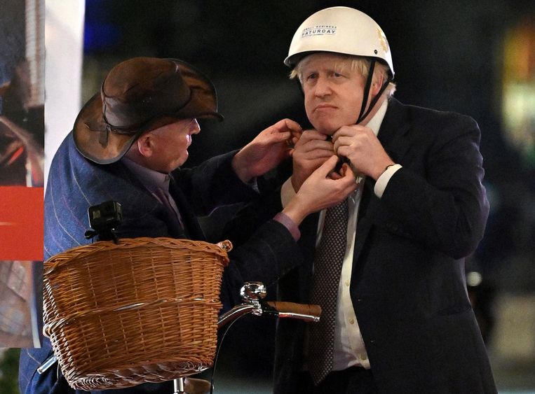 Een van de memorabele Boris Johnson-momenten tijdens zijn premierschap. Johnson met helm op tijdens een 'UK Food and Drinks market'.  Beeld REUTERS