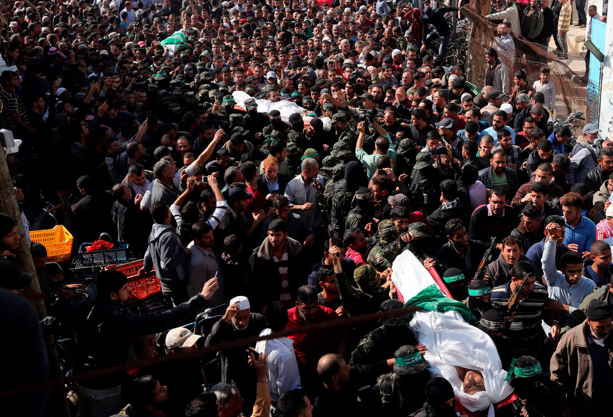 Een massa Palestijnen draagt de gesneuvelde lichamen van de Hamas-strijders die zijn omgekomen bij de missie. Beeld AFP