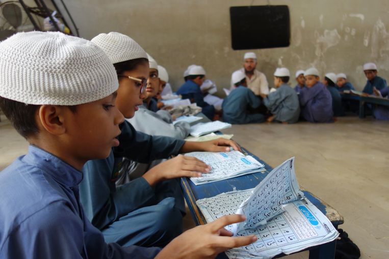 Jongens leren de koran uit hun hoofd in een madrassa, een religieuze school, in de Pakistaanse stad Karachi. Beeld Arjen van der Ziel