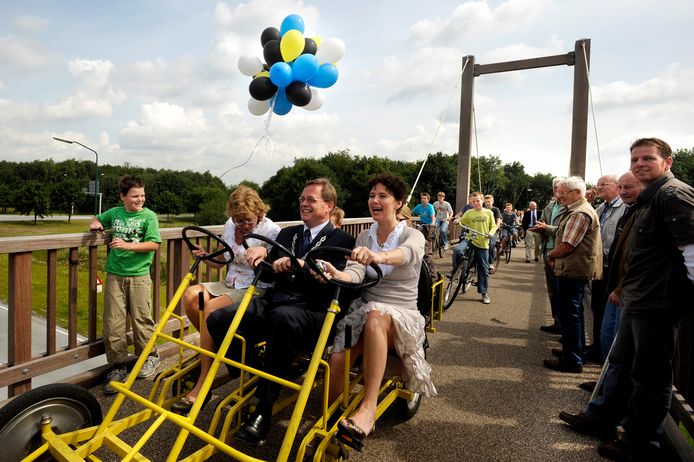 Feestelijk moment voor Stefan Huisman: hij opent te midden van wethouder Mieke Hendrikx (links) en Brabants gedeputeerde Cora van Nieuwenhuizen een fietsbrug.