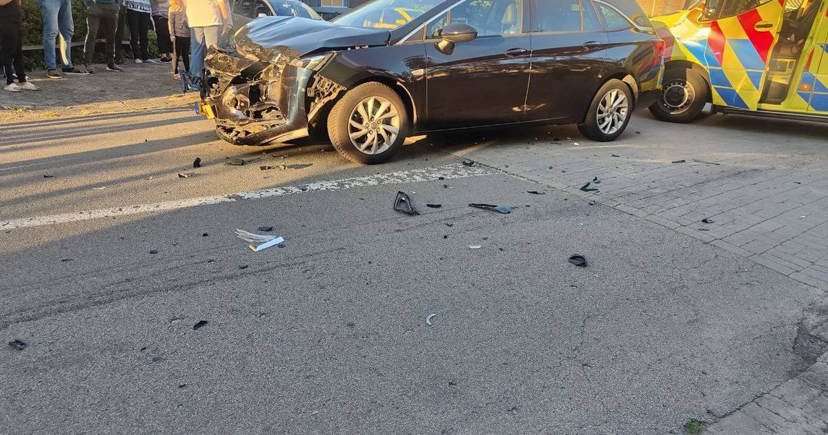 Veel schade door aanrijding tussen twee autos in Enschede: weg bezaaid met brokstukken.