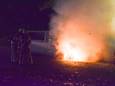 Brandweermannen proberen het busje te blussen.