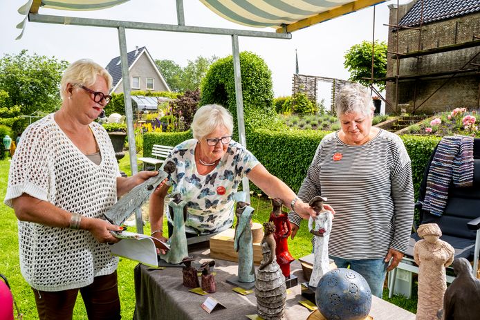 Kunstenares Ada Andreae (links) bij het werk van haar cursisten Ria Walbroek (midden) en Clementine Driessen. De twee zussen uit Rockanje exposeren dit weekend in de tuin van Andreae's Beeldenboerderij Frederik’s Hoeve in Oudenhoorn.