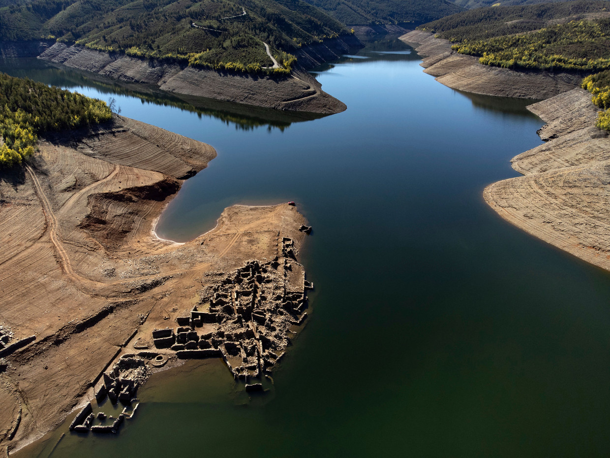 In deze luchtfoto, gemaakt met een drone, steken de ruïnes van het oude dorp Vilar, dat onder water ligt sinds 1954 toen door de bouw van een waterkrachtdam de vallei overstroomde, uit boven het water van de rivier de Zezere, in de buurt van Pampilhosa da Serra in Portugal. Delen van het land hebben last van extreme droogte.  Beeld Sergio Azenha/AP