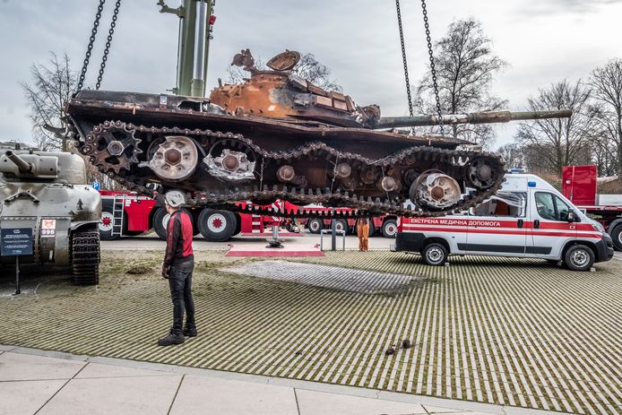 De Russische tank wordt op de parkeerplaats gehesen, de ambulance staat er al.