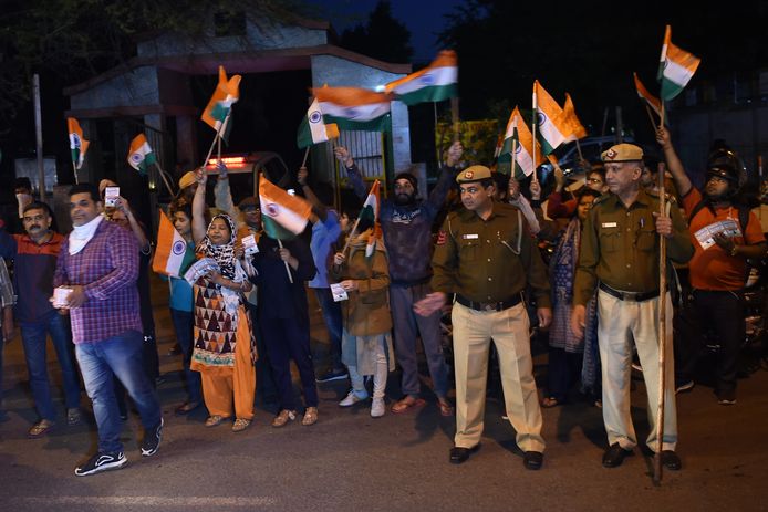 Demonstranten zwaaiend met de Indiase vlag en politieagenten drommen samen voor de gevangenis van Tihar waar de verkrachters werden geëxecuteerd.