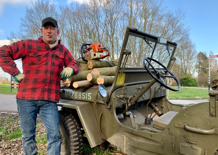 Alexander Lorsheijd (48) uit Lexmond heeft een omgevallen boom kortgezaagd en brengt de takken en stammetjes thuis met z'n jeep.