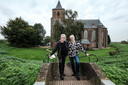 Marjolein Bultena (rechts) en Joop Boxstart voor de Martinuskerk in Oud-Zevenaar. De kerk is een van de iconische gebouwen in het dorp en speelt in rol in zowel het boek als de film die over het Liemerse dorp verschijnen.