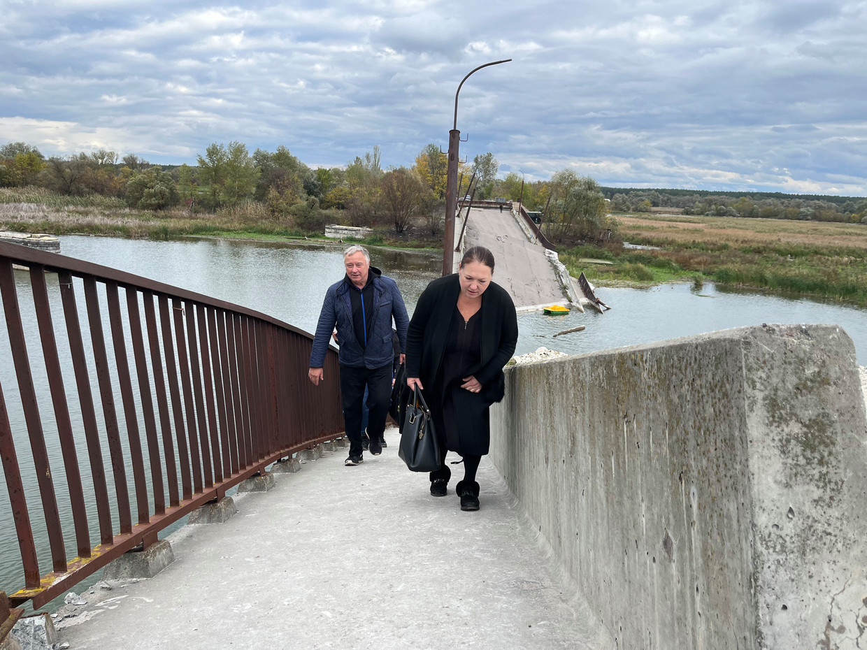 Valerie en zijn vrouw Svetlana Govoroen op een kapotgeschoten brug bij Roebizjne, op weg naar de moeder van Svetlana te bezoeken.  Beeld Michiel Driebergen