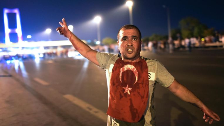 Een man bij de Bosporus Brug in Istanbul, de nacht na de couppoging in Turkije. Beeld afp