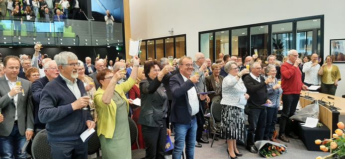 Een toast op de koning. Een aantal kersvers gedecoreerden staan op de voorgrond.