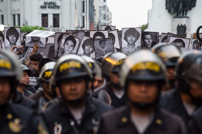 Police stand by as demonstrators march during a protest against the pardon of former Peruvian President Alberto Fujimori in Lima, on December 28, 2017. 
Peruvian President Pedro Pablo Kuczynski granted a humanitarian pardon Sunday to ex-president Alberto Fujimori, who has been hospitalized since Saturday and is serving a 25-year sentence for crimes against humanity. / AFP PHOTO / Ernesto BENAVIDES