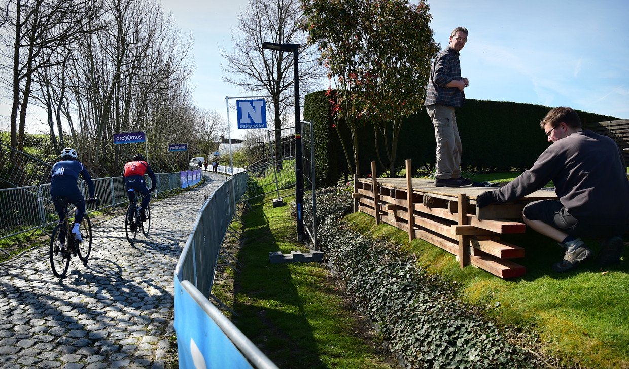 Terwijl renners de helling van de Oude Kwaremont verkennen, bouwen bewoners langs de route hun podiumpje om zondag de Ronde van Vlaanderen goed te kunnen zien. Beeld Marcel van den Bergh / de Volkskrant