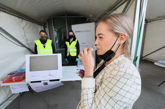 Een student spuugt in een buisje bij Fontys als test tegen corona. Ze doet zo mee aan de pilot om fysiek onderwijs weer mogelijk te maken op de 'oude' manier.