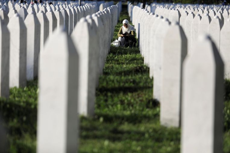 Een vrouw bidt tussen de grafstenen van de slachtoffers van Srebrenica. Beeld Getty Images
