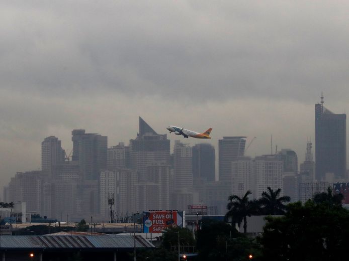 Een vliegtuig stijgt op boven Makati City in de Filipijnen.
