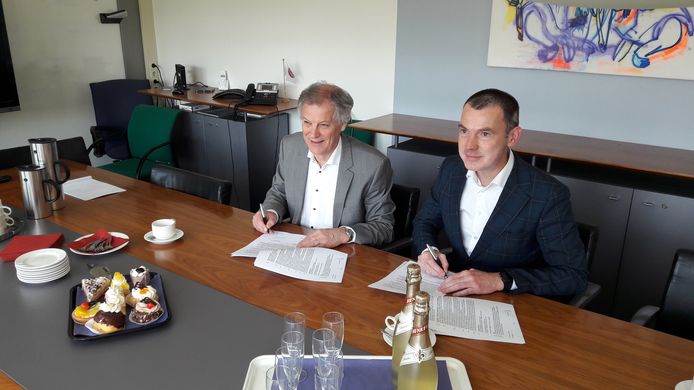 Wim van Harten (links) en wethouder Wijnte Hol zetten hun handtekening onder de plannen om in Elst een nieuwe poli-kliniek te bouwen.