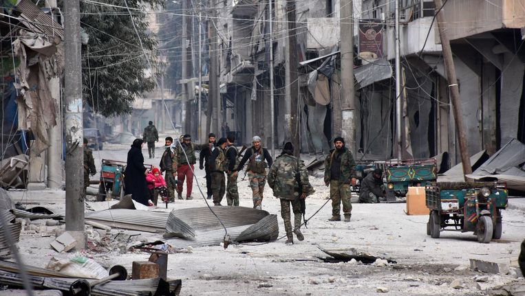 Syrische troepen lopen door al-Salihin nadat ze de buurt in het oosten van Aleppo hebben heroverd van rebellen. Beeld AFP