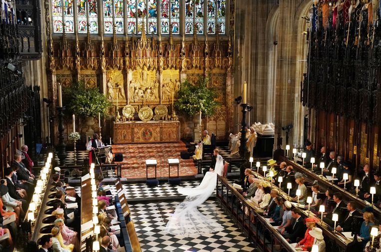 Prins Harry en Meghan Markle luisteren naar de preek van Michael Curry. Beeld REUTERS