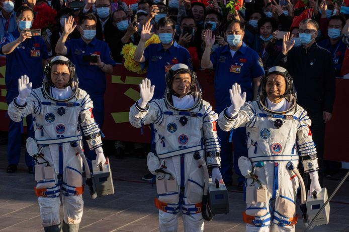 De Chinese astronauten Tang Hongbo, Nie Haisheng, en Liu Boming zwaaien tijdens een vertrekceremonie voorafgaande aan hun ruimtevlucht naar het Hemels Paleis 'Tiangong', het eerste echte ruimtestation van het land.