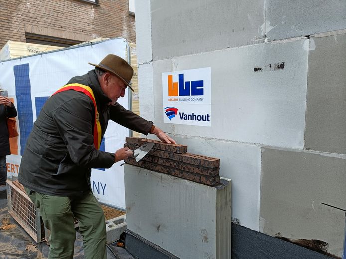 Burgemeester Rudy Van Cronenburg legt mee de eerste steen van de nieuwbouw.