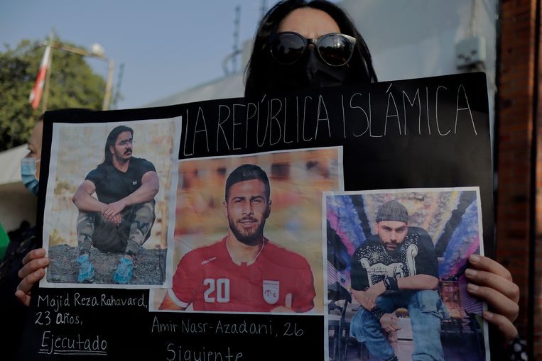 Protest bij de Iraanse ambassade in Mexico City. De vrouw houdt onder meer een afbeelding omhoog van voetballer Amir Nasr-Azadani. Beeld Getty