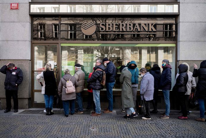 Mensen staan in Praag in de rij bij de Sberbank om al hun geld daar weg te halen.