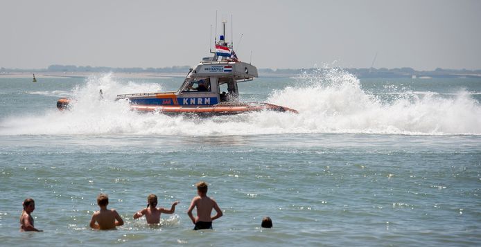 Een passerende reddingsboot van de KNRM op het strand in Vlissingen.