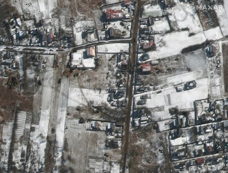 Ten noorden van de luchtmachtbasis in Hostomel zijn Russische militaire voertuigen te zien op wegen in residentiële gebieden in Ozera, op ongeveer 27 kilometer van Kiev. Beeld EPA