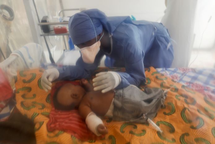 Een hulpverlener bekommert zich om een 3 maanden oude baby die aan de besmettelijke ziekte lijdt.