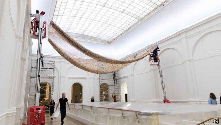 Het doek van Keith Haring wordt maandag opgehangen boven de marmeren trap in het Stedelijk Museum Amsterdam. Beeld Hans Poel
