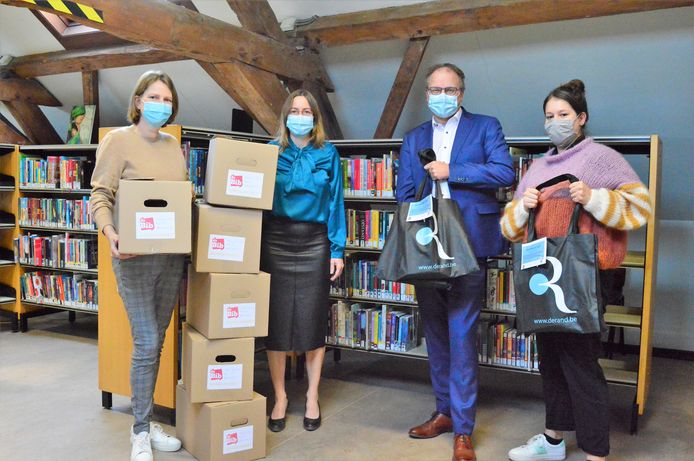 Schepenen Jan Desmeth en An Speeckaert samen met de medwerkers van de bibliotheek in Sint-Pieters-Leeuw die de pakketten samenstellen.