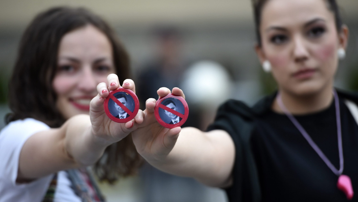 Demonstranten houden een button omhoog met daarop de premier Nikola Gruevski tijdens een protest in Skopje, Macedonië. Beeld epa