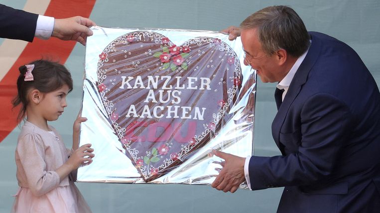 Een meisje geeft Armin Laschet een peperkoeken hart, ‘Kanselier uit Aaken’, tijdens de verkiezingscampagne. Beeld EPA